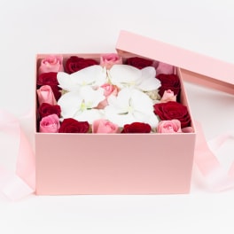Pink gift box with red and pink roses and white orchids