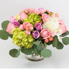 Pink and purple roses with hydrangeas in a glass vase