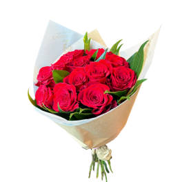 Bouquet of red roses wrapped in pale paper