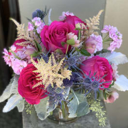 Bouquet of hot pink roses with lavender accents in a glass vase