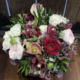 Bouquet of white roses, burgundy ranunculus, and pink calla lilies