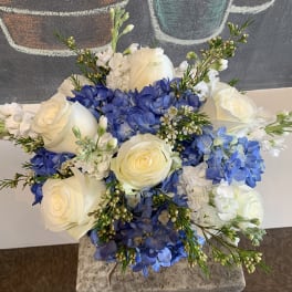 Bouquet of white roses and blue hydrangeas with small white filler flowers