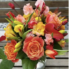 Bouquet of orange, pink, and yellow flowers in a glass vase