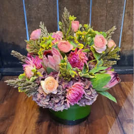 Pink and lavender floral arrangement in a green vase