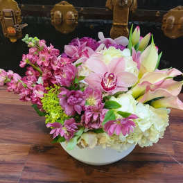 Pink and white mixed flower arrangement in a white bowl vase