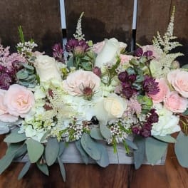 Low floral centerpiece with pink and white roses and purple accents