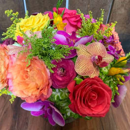 Colorful bouquet of roses, orchids, and ranunculus in a vase