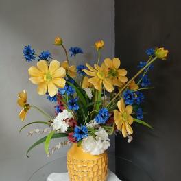 Yellow and blue flowers arranged in a patterned vase