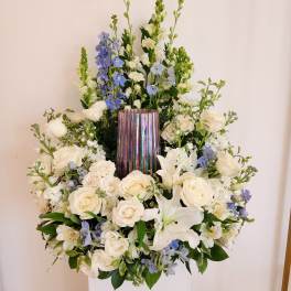 White and blue floral arrangement in a metallic vase