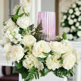 White rose arrangement with a pink glass vase centerpiece