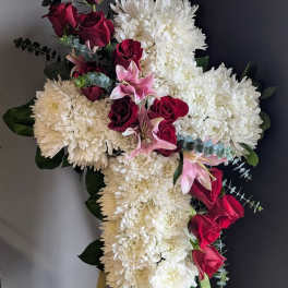 Cross-shaped floral spray with white chrysanthemums, red roses, and pink lilies