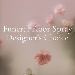 Pink floral funeral floor spray with soft blossoms on a pale background