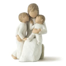 Three child figurines in white clothing grouped together
