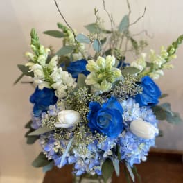 Blue and white floral arrangement in a glass vase