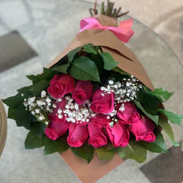 Bouquet of hot pink roses with baby's breath wrapped in brown paper