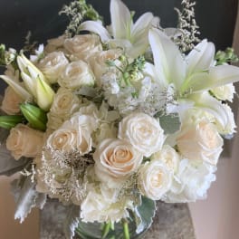 White roses and lilies arranged in a glass vase
