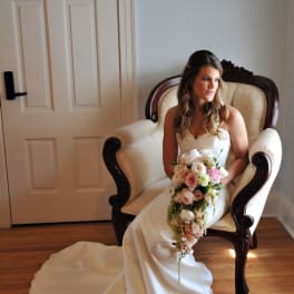Bride in a white gown holding a cascading bouquet of pink and white flowers