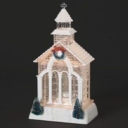 Decorative church-shaped holiday display with lights and small trees