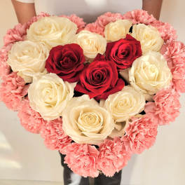 Heart-shaped bouquet of red and white roses edged with pink carnations