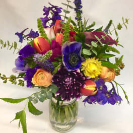 Colorful mixed bouquet in a clear glass jar vase