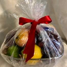 Cellophane-wrapped basket of assorted fruit tied with a red ribbon