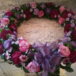 Heart-shaped floral wreath with pink roses and purple flowers