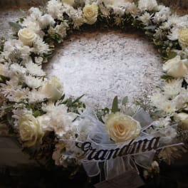 White floral wreath with roses and daisies on a countertop