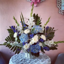 Blue and white floral arrangement in a white vase