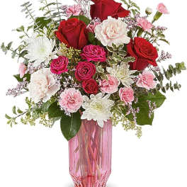 Pink and red flower bouquet in a tall pink glass vase