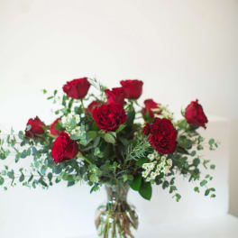 Red roses arranged in a clear glass vase