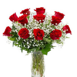 Red roses arranged in a clear glass vase with white baby's breath