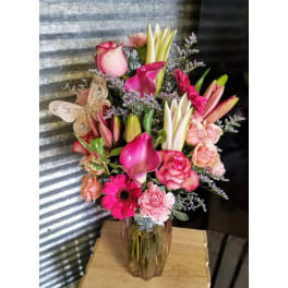 Pink and white mixed bouquet in a glass vase with a butterfly decoration