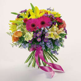 Colorful bouquet with pink gerbera daisies and yellow lilies tied with a pink ribbon