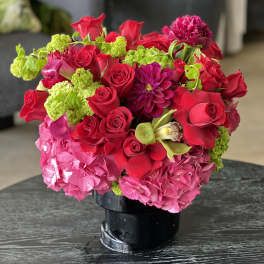 Bouquet of red and pink flowers in a black vase