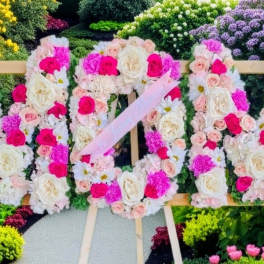 Large floral sign made of pink and white roses on an easel