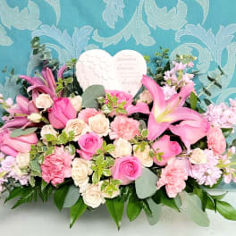 Pink and cream floral arrangement with lilies, roses, and a heart plaque