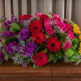 Large mixed bouquet with red gerberas, pink roses, purple flowers, and yellow sunflowers