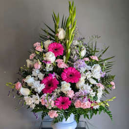 Tall mixed floral arrangement in a white vase with pink and white blooms
