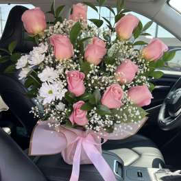 Pink roses and white daisies in a wrapped bouquet
