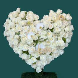 Heart-shaped white rose arrangement with a "love" sign