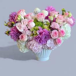 Pink and purple mixed bouquet in a white vase