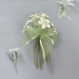 White floral bouquet with a matching boutonniere on a pale background