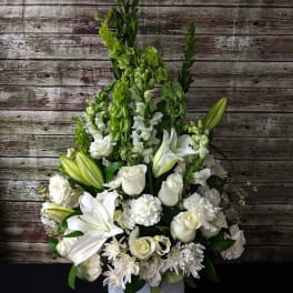 White floral arrangement in a white pedestal vase