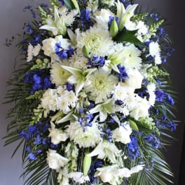 Large white and blue funeral spray on a standing easel