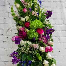 Tall mixed floral arrangement with pink, white, purple, and blue blooms