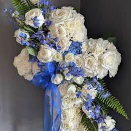 White rose and hydrangea floral spray with blue ribbon and blue flowers