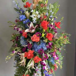 Tall mixed floral standing spray with red roses and blue flowers