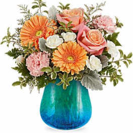 Pink roses and orange gerbera daisies in a blue glass vase