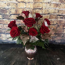 Red roses arranged in a small glass vase