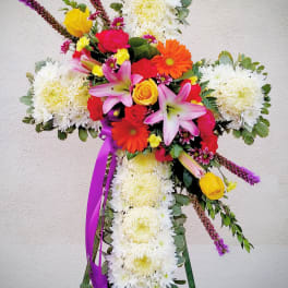 Cross-shaped floral tribute with white chrysanthemums and bright mixed blooms